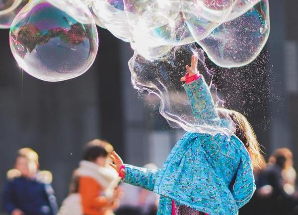girl playing with giant bubble