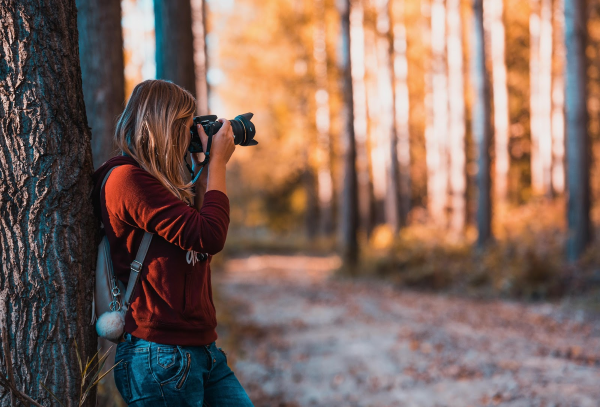 young girl taking photos in the woods