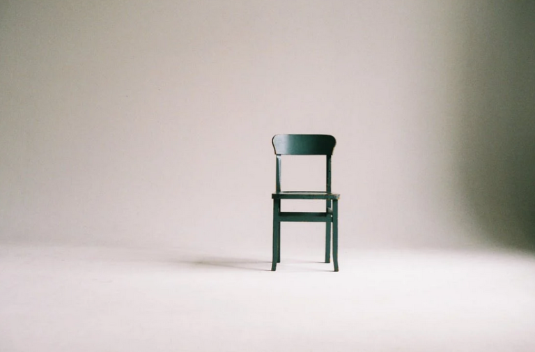 green wooden chair in an empty room