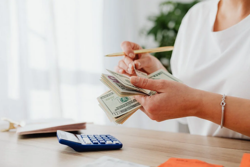 woman counting cash and calculator