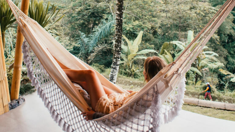 A woman relaxes in a hammock while vacationing.